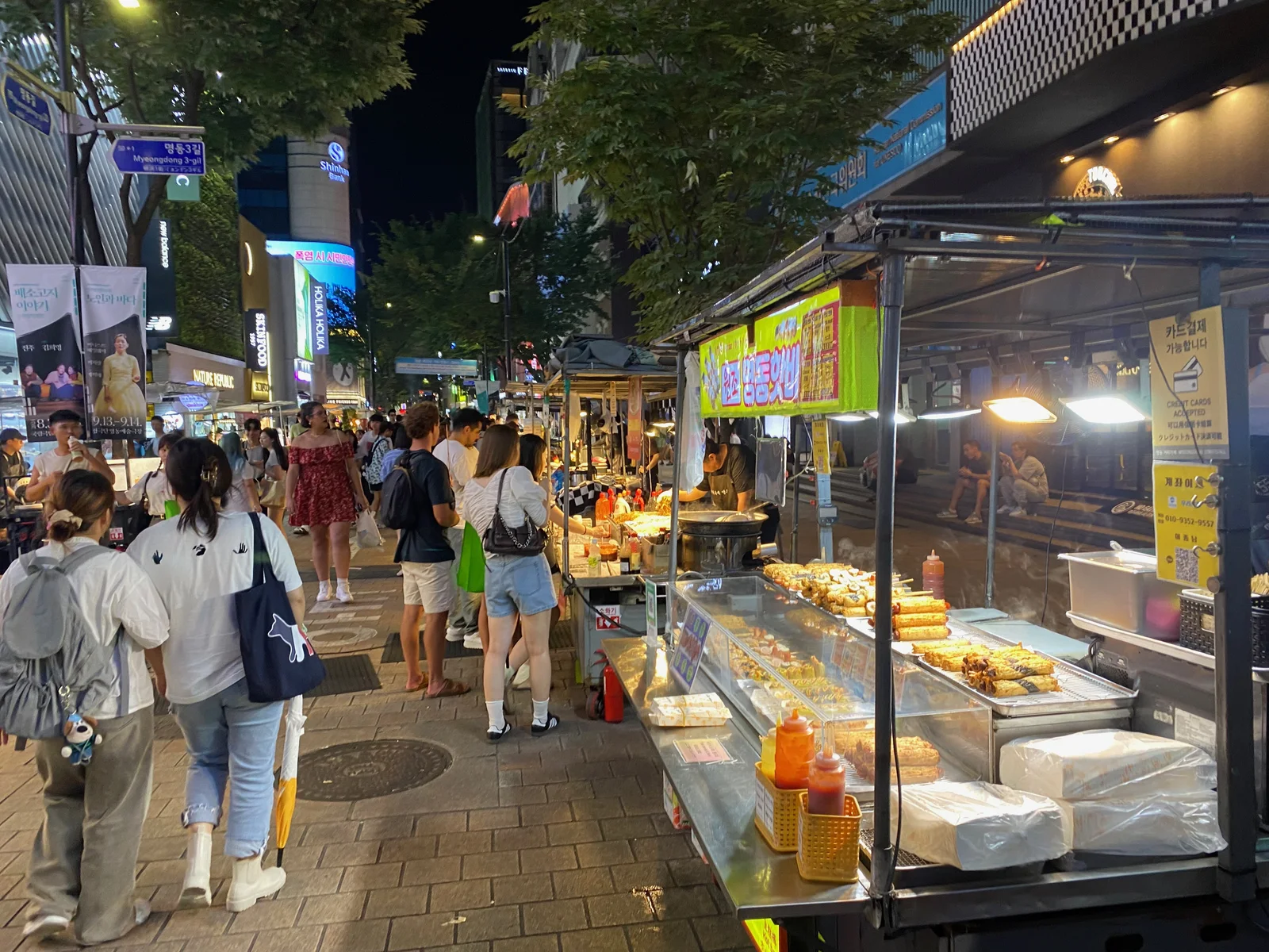 명동 야시장 노점 앞에서 음식을 고르는 방문객